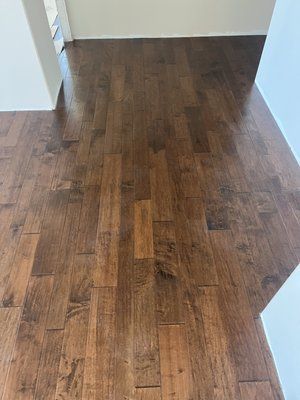 A wooden floor in a room with a white wall.