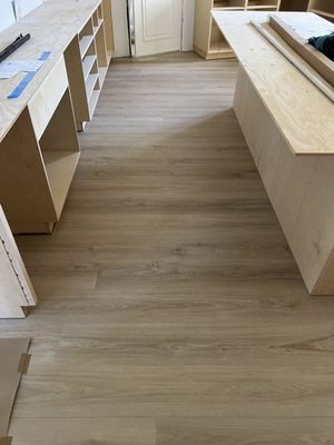 A room with a wooden floor and a wooden table.