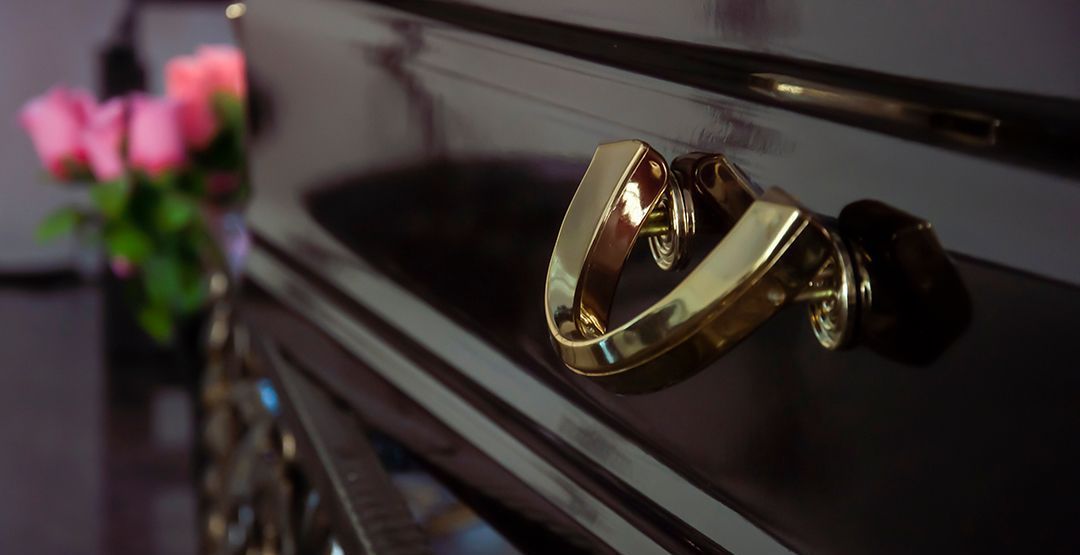 a close up of a gold handle on a black coffin .