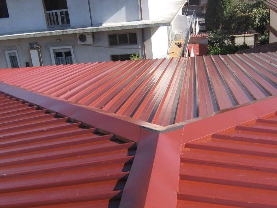 Un tetto rosso con un edificio bianco sullo sfondo