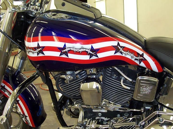 American flag-themed motorcycle with blue, red, and white stripes, stars, and chrome detailing.
