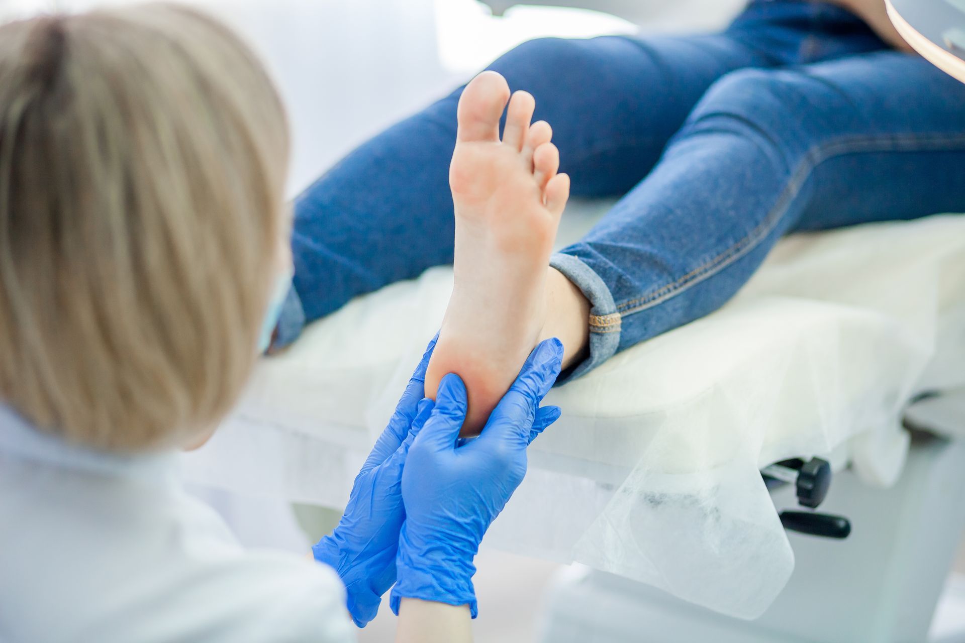 A podiatrist is checking a patient’s feet.