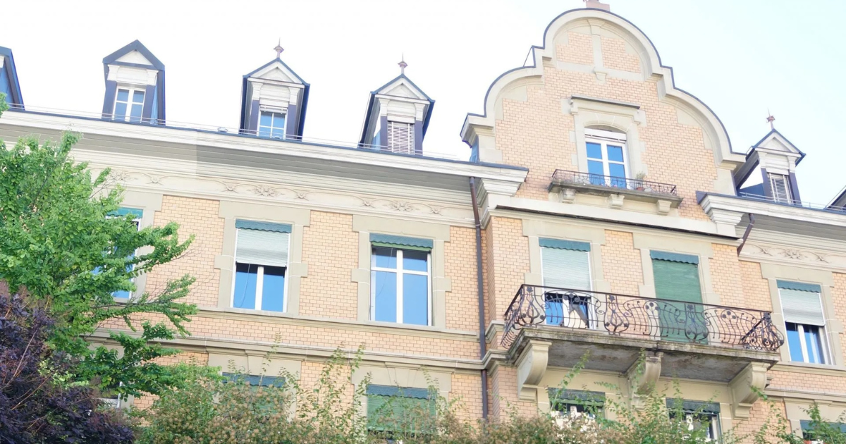 Grosses Backsteingebäude mit vielen Fenstern und einem Balkon