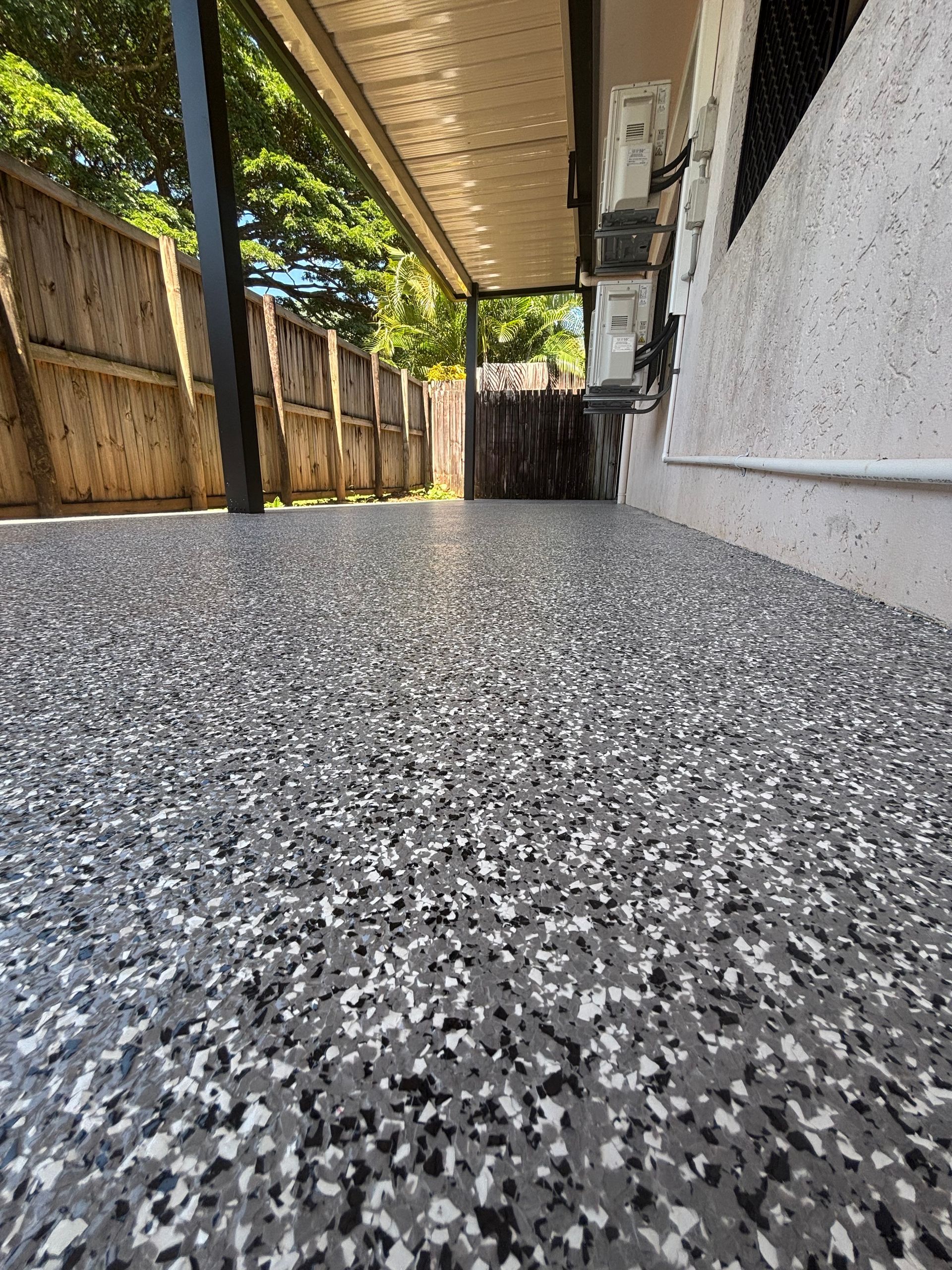Room with reflective epoxy floor featuring green, black, and white swirls. Black and teal walls, illuminated frames — Supremacy Painting Co In White Rock, QLD