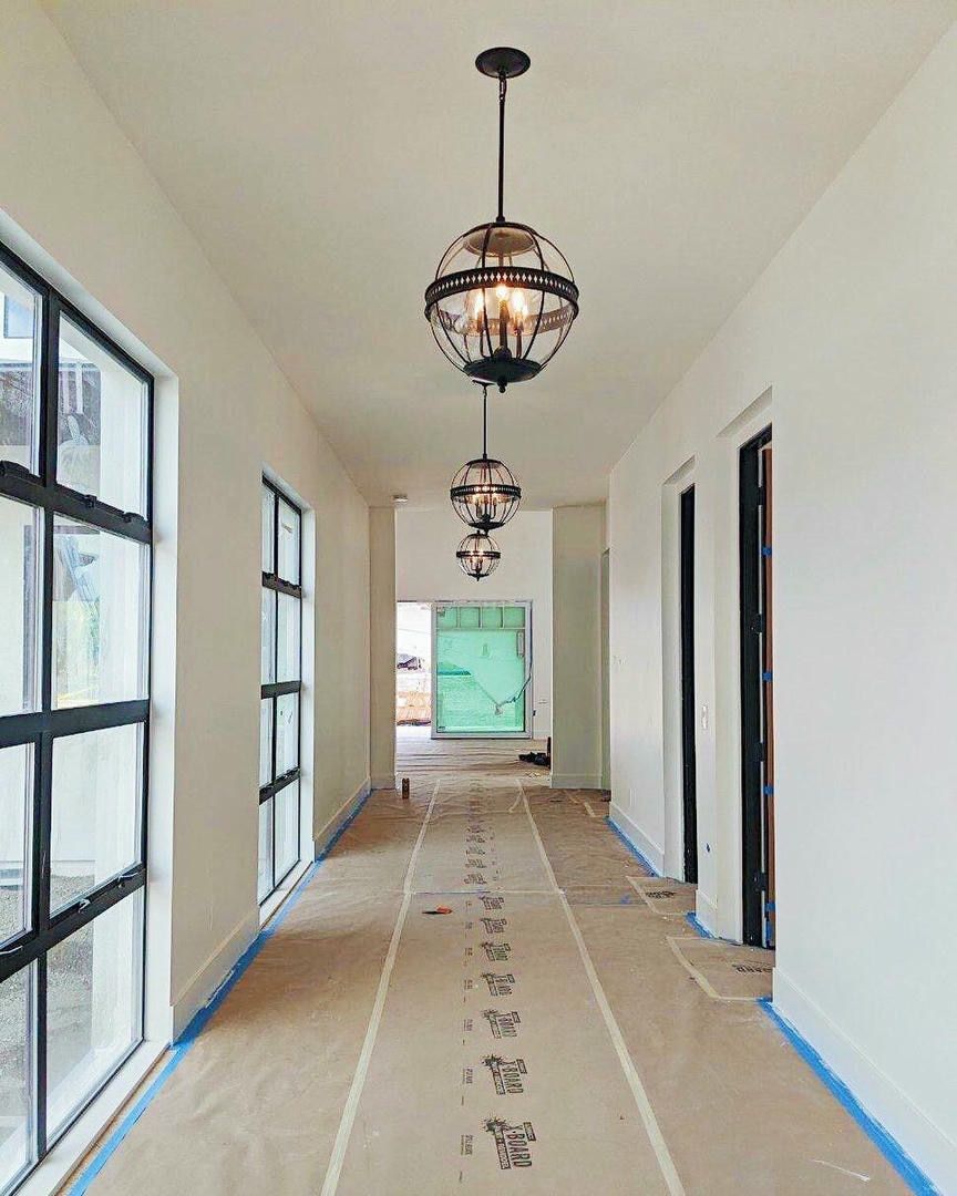 A long hallway with a chandelier hanging from the ceiling