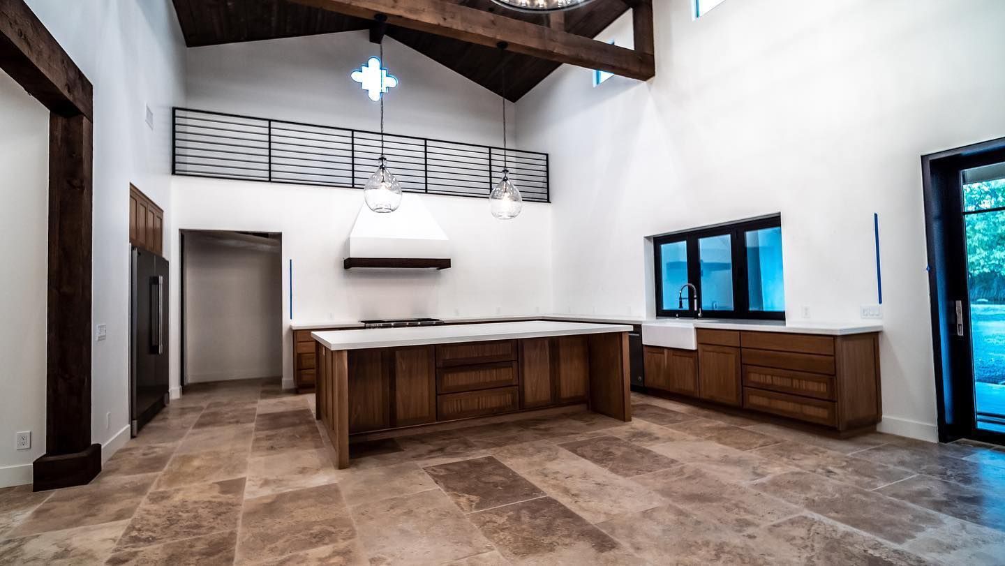 An empty kitchen with a large island in the middle of the room.