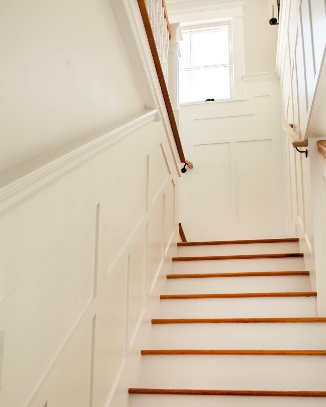 A staircase with white walls and wooden steps