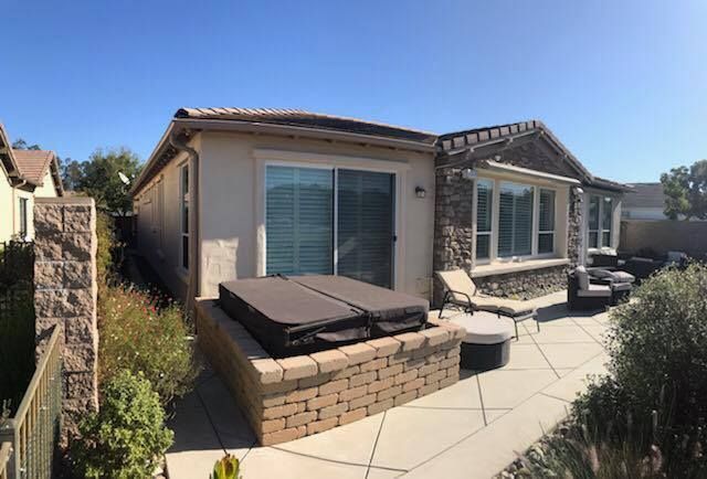 A house with a hot tub in the backyard.