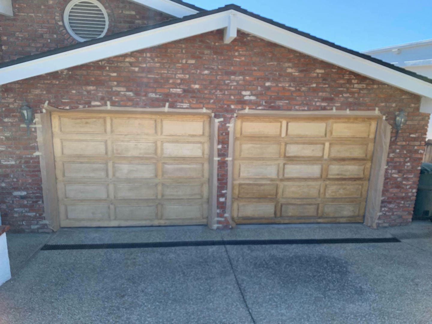 A brick house with two wooden garage doors