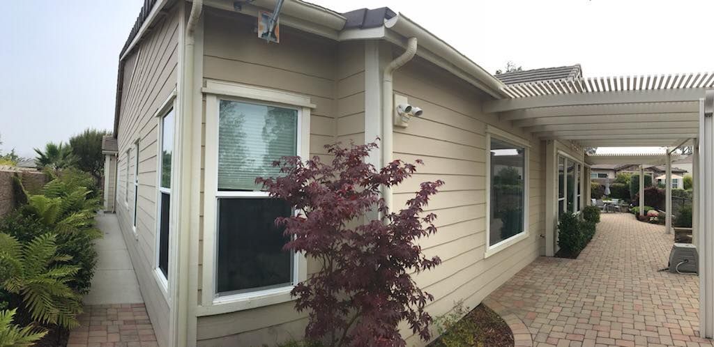 A house with a walkway leading to it and a tree in front of it