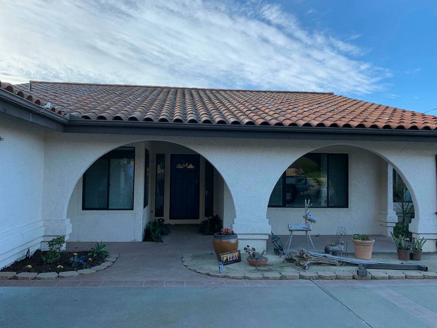 A white house with arches and a tile roof.