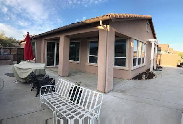 A house with a patio and a bench in front of it.