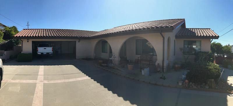 A white truck is parked in front of a large house.
