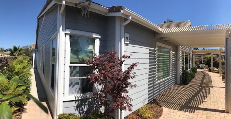 A house with a lot of windows and a tree in front of it.
