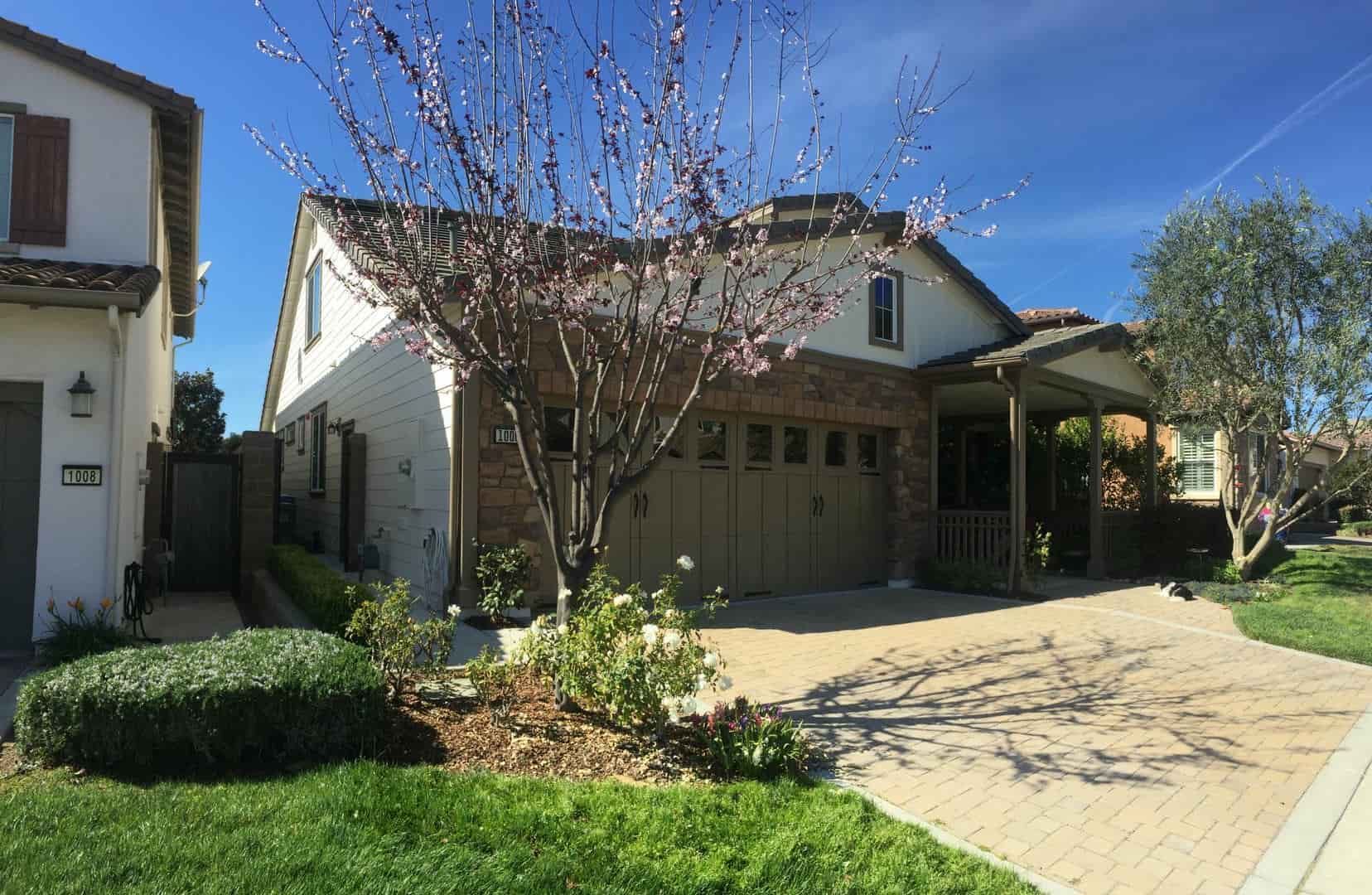 A house with a garage and a tree in front of it