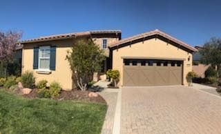 A large yellow house with a garage and a driveway.