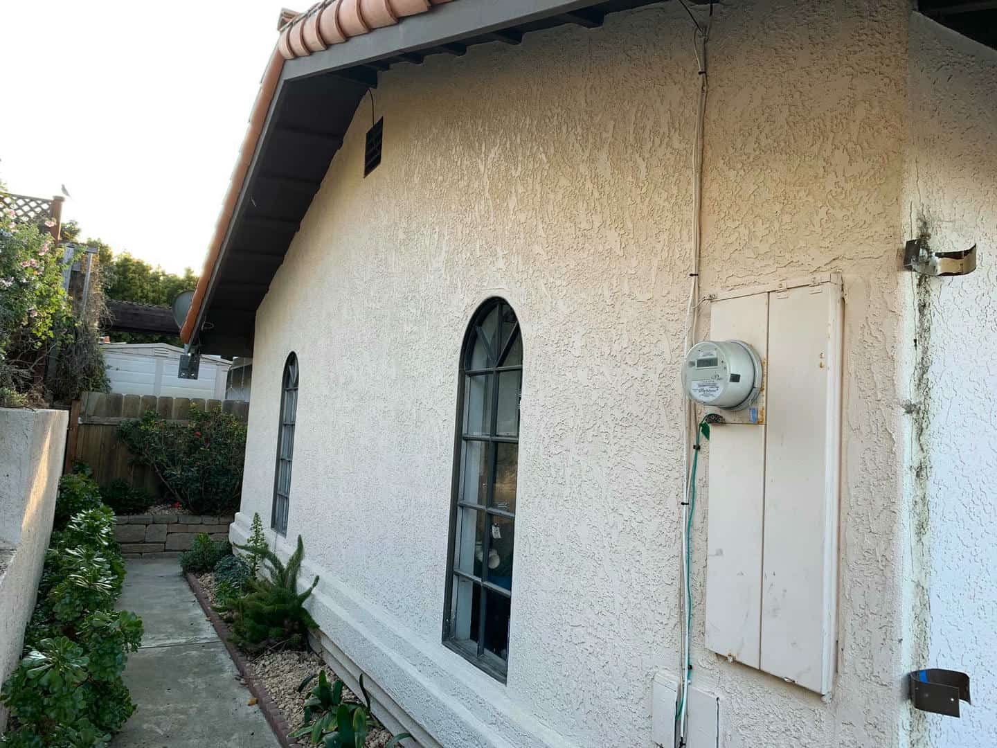 The side of a house with a hose attached to it.