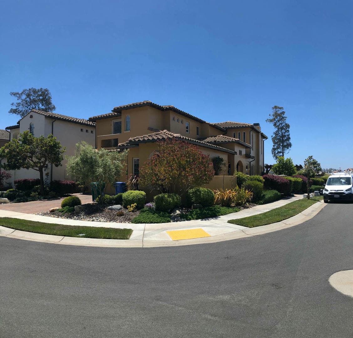 A white truck is parked in front of a large house