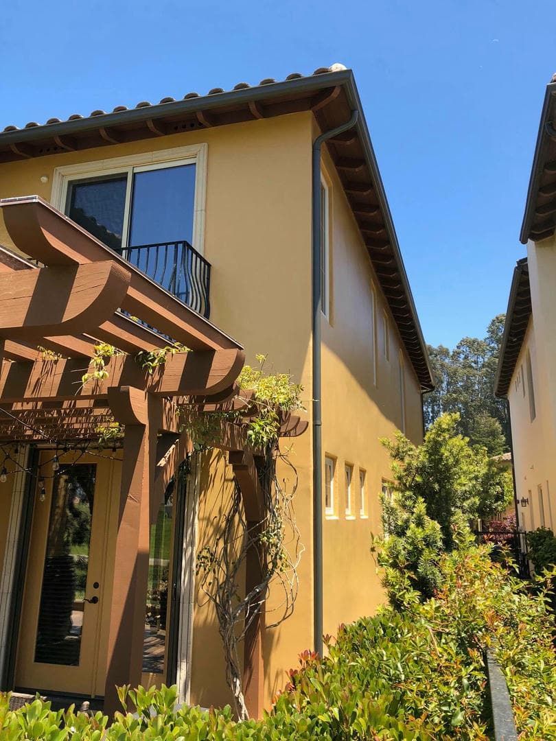 A house with a balcony and a pergola on the side of it.