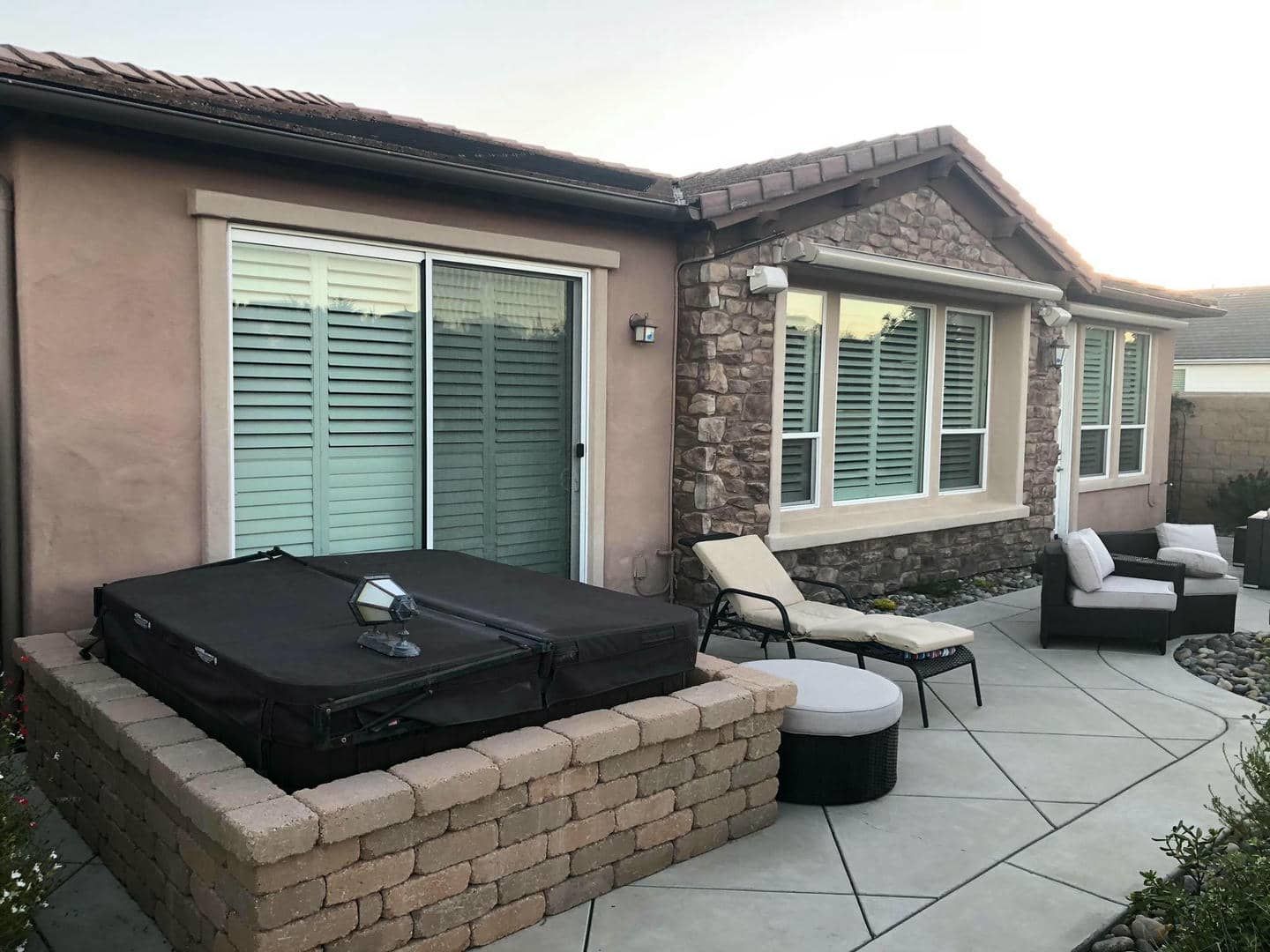 There is a hot tub in the backyard of a house.