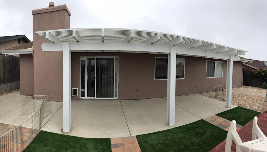 A house with a pergola and a sliding glass door