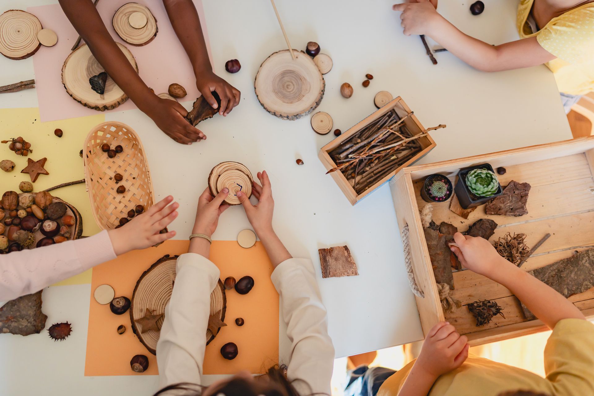 Hands arranging sticks and leaves during a nature-based activity. Hands arranging sticks and leaves during a nature-based activity.