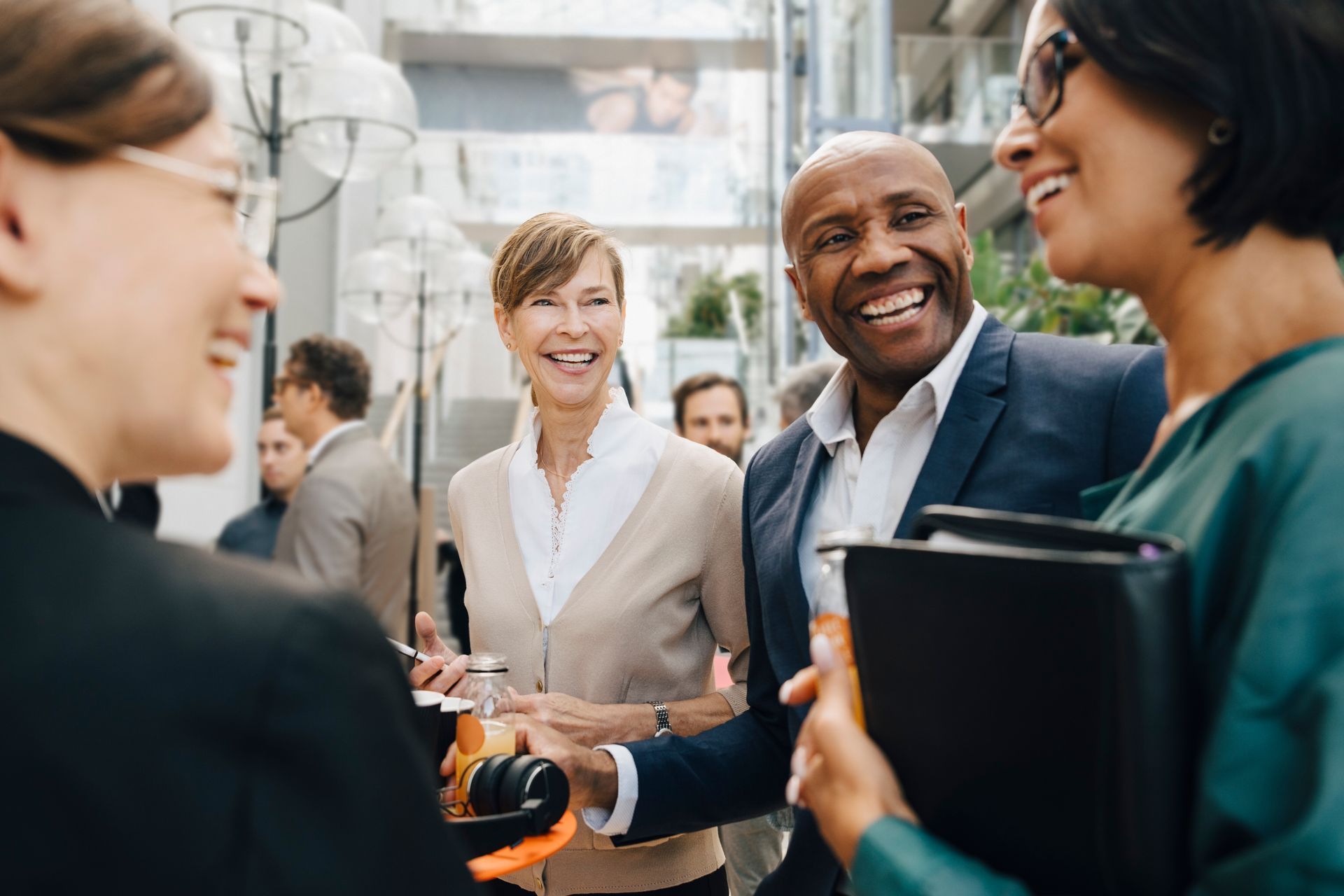 A group of business people are standing around talking to each other.