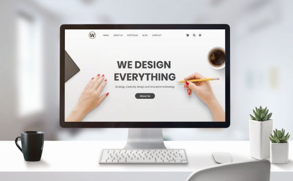 A computer monitor on a desk that says we design everything