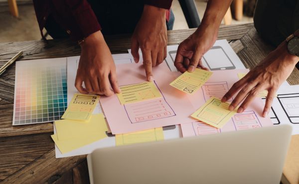 A group of people are sitting at a table working on a project.