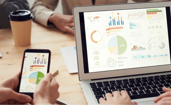 A group of people are using a laptop and a cell phone