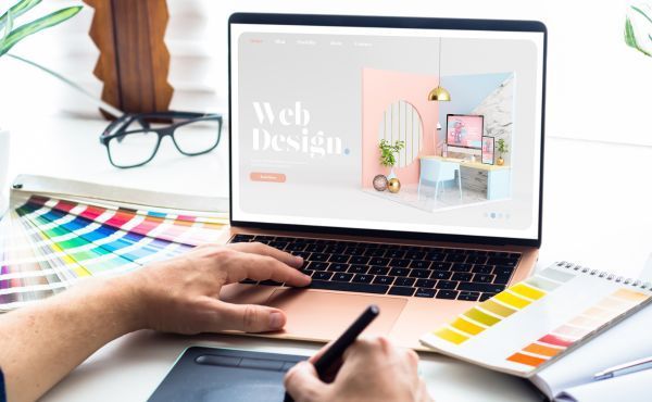 A person is using a laptop computer to create a website.