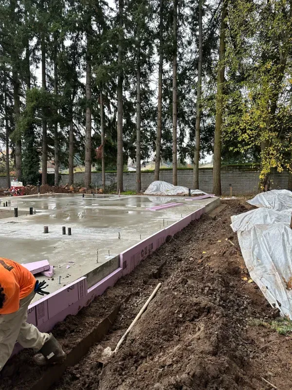 A concrete walkway is being built in front of a building under construction in Vancouver, WA