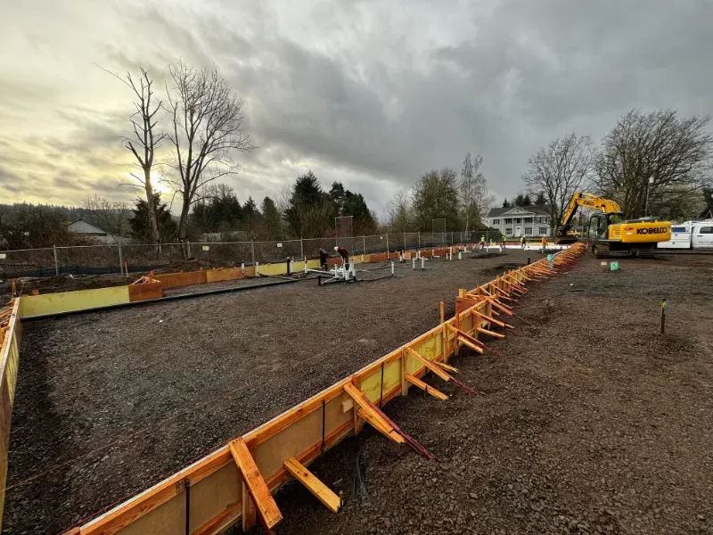 A concrete walkway is being built in front of a building under construction in Vancouver, WA