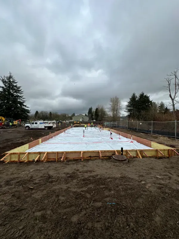 A concrete walkway is being built in front of a building under construction in Vancouver, WA