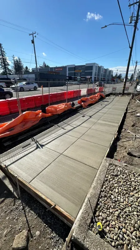 A person is working on a concrete sidewalk in front of a building in Vancouver, WA