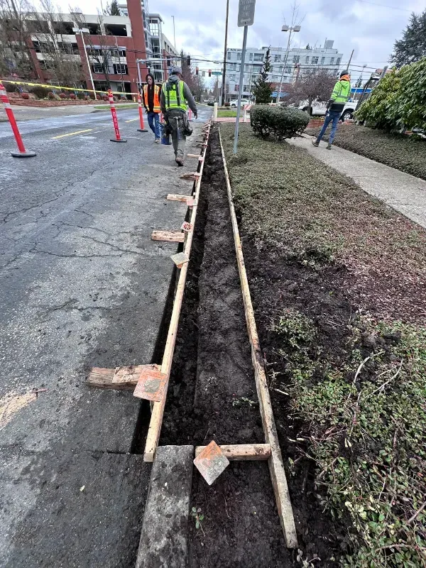 A couple of men are working on a concrete sidewalk in Vancouver, WA