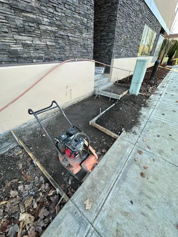 A brick walkway is being built in front of a large building in Vancouver, WA