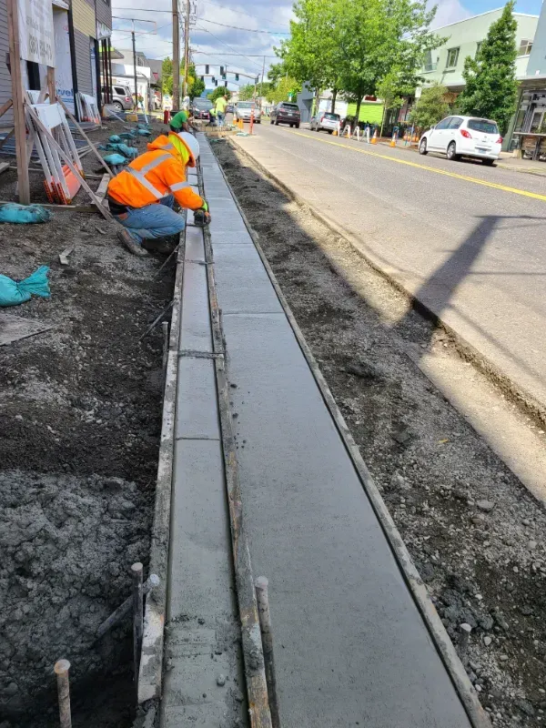 A concrete walkway is being built in front of a building under construction in Vancouver, WA