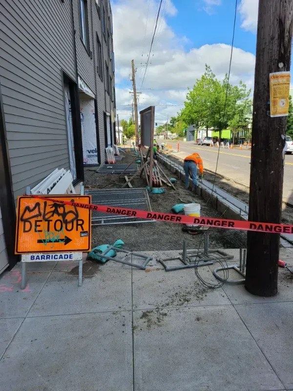 A concrete walkway is being built in front of a building under construction in Vancouver, WA