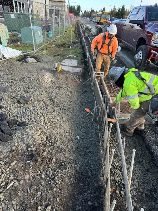 A person is working on a concrete sidewalk in front of a building in Vancouver, WA