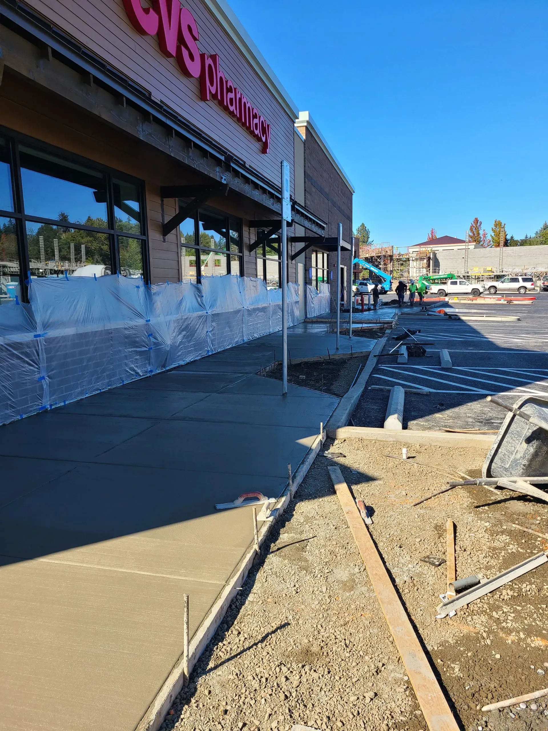 A concrete mixer truck is being loaded with concrete in a parking lot in Vancouver, WA