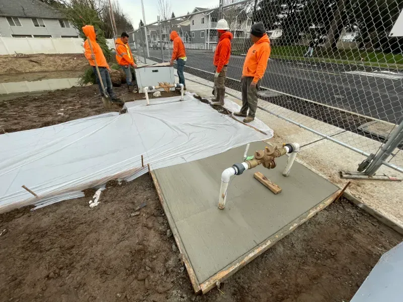 A concrete walkway is being built in front of a building under construction in Vancouver, WA