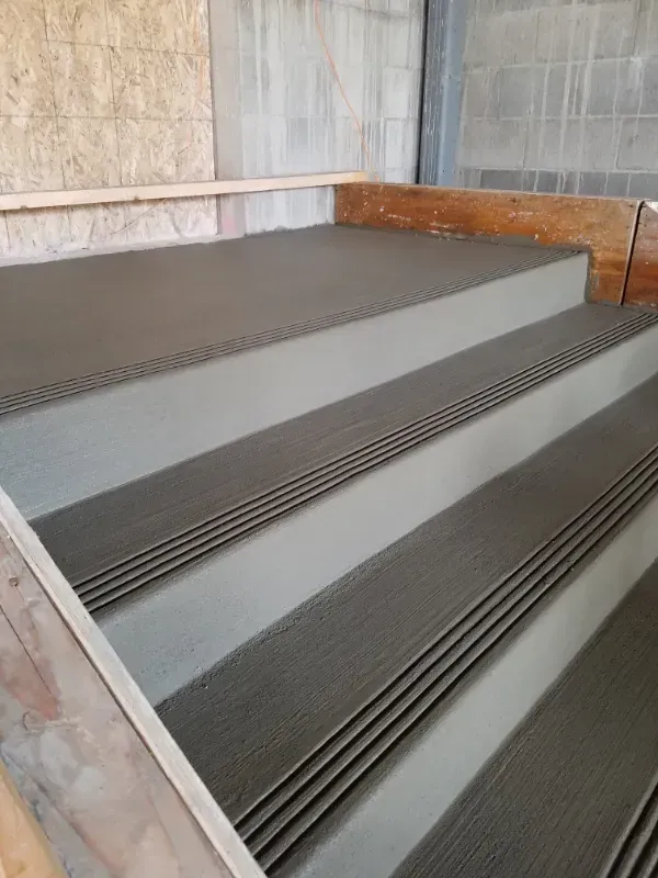 A close up of a set of stairs with a wooden railing in Vancouver, WA by NAVA Concrete LLC