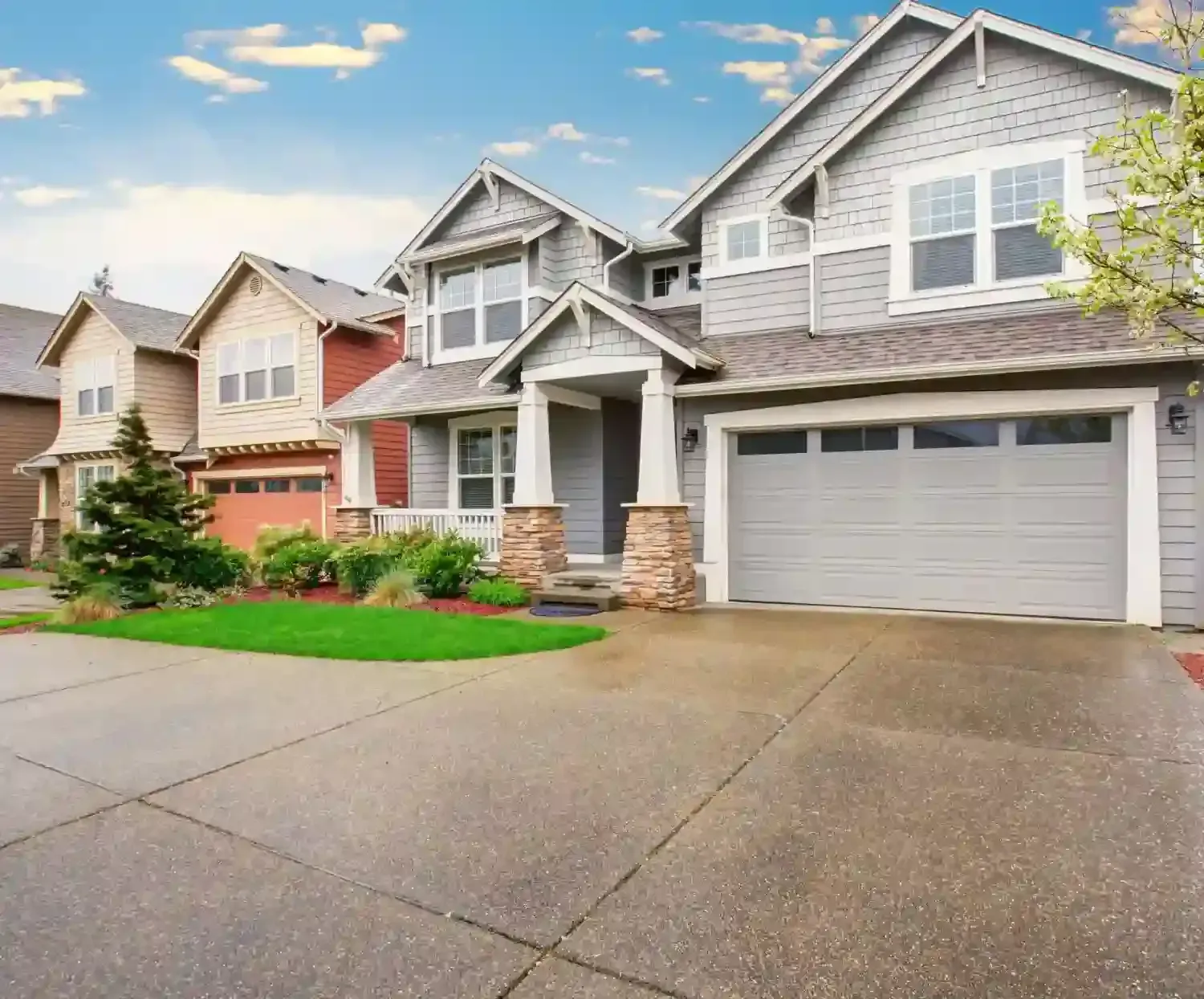 A row of houses with a concrete driveway in front of them