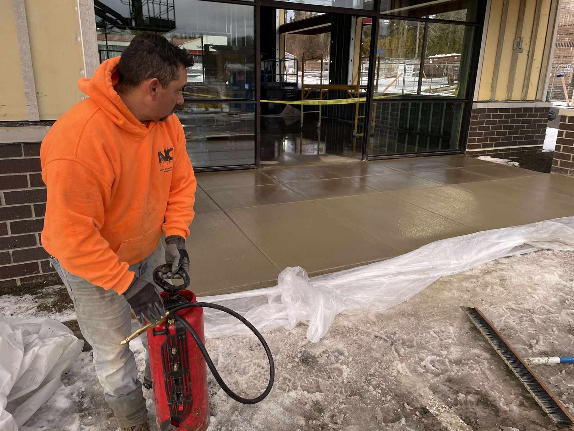 A man is using a fire extinguisher to extinguish a fire on a sidewalk in Vancouver, WA