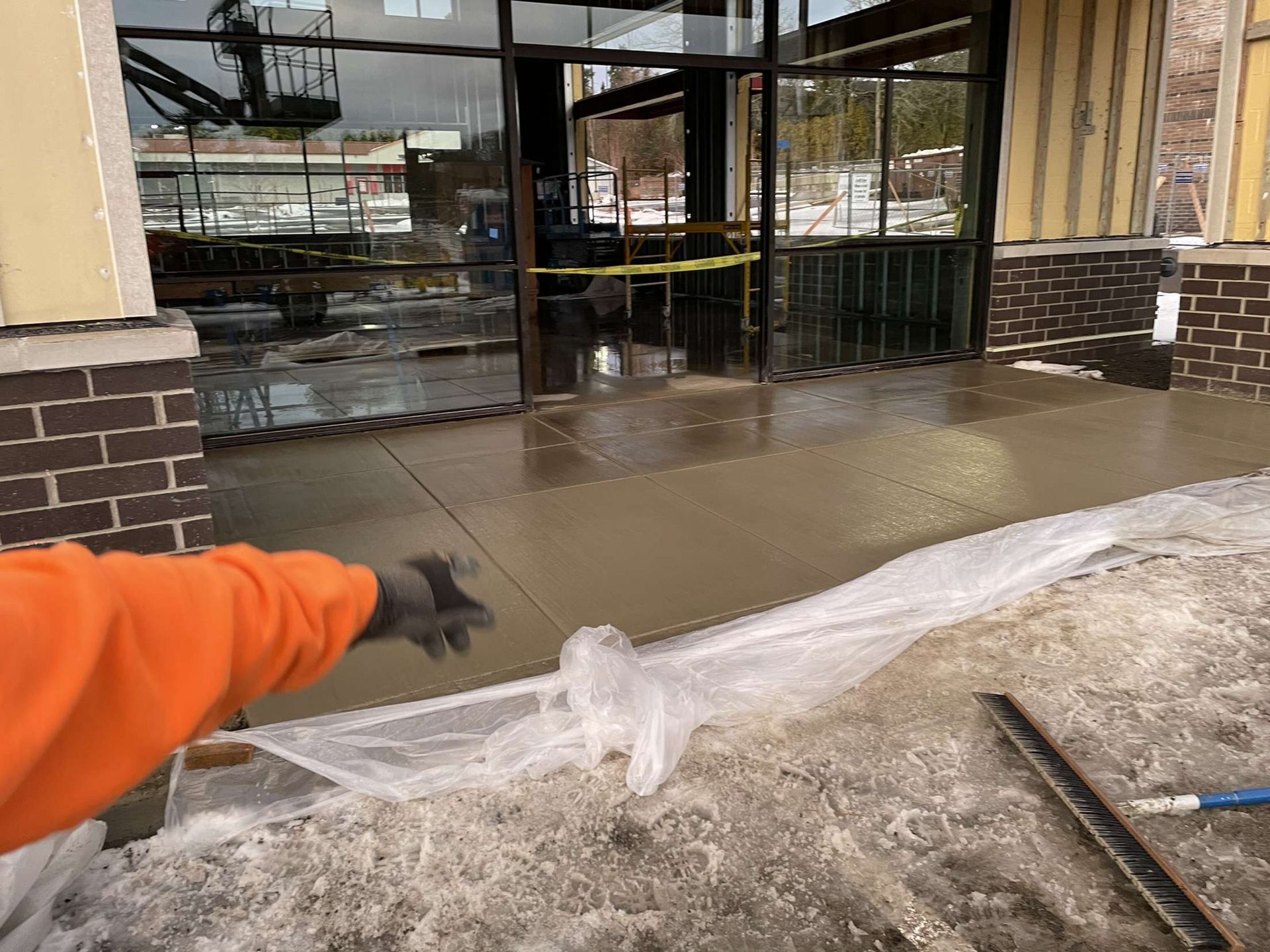 A person is working on a concrete sidewalk in front of a building in Vancouver, WA
