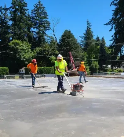 A group of construction workers are working on a concrete surface