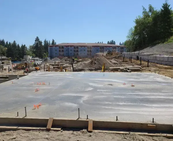A group of construction workers are working on a concrete foundation.