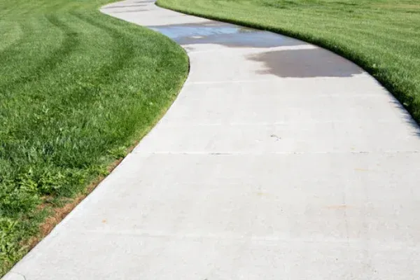 Curving concrete walkway through green lawn in Vancouver WA.