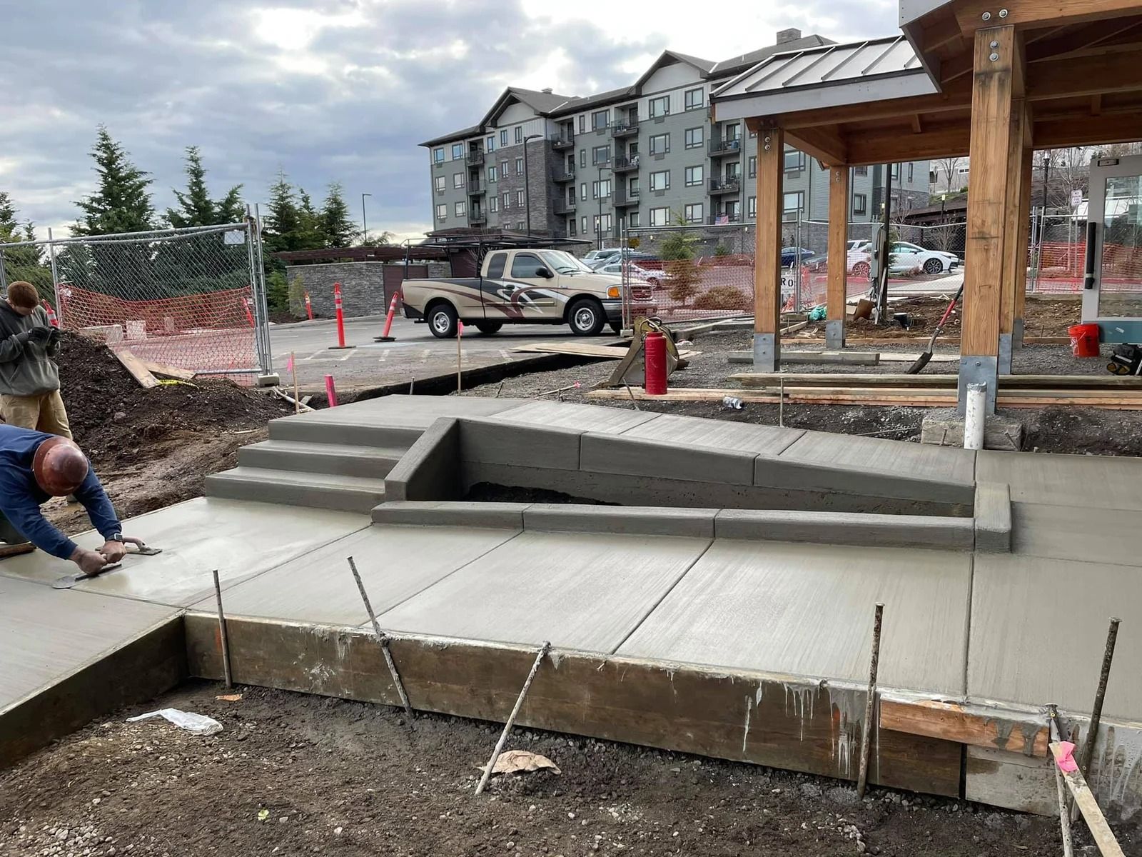 A man is working on a concrete walkway at a construction site in Vancouver, WA by NAVA Concrete LLC